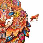 Pezzi di puzzle in legno colorati con motivi intricati che formano la forma della faccia di un leone e un piccolo pezzo separato a forma di orso di Gentle Lynx Unidragon Animali.