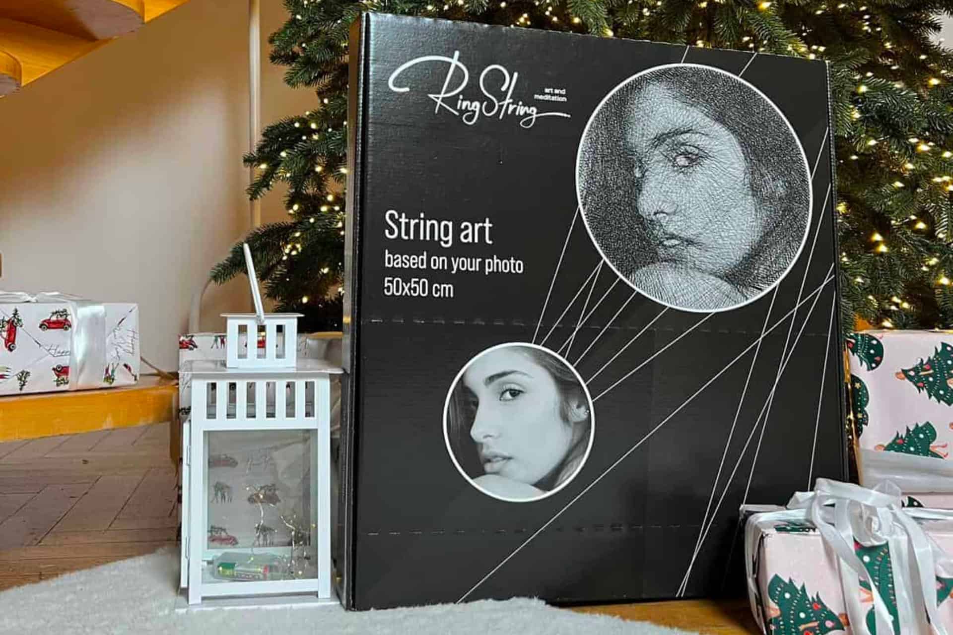 Una scatola con la foto di una donna accanto a un albero di Natale, creata utilizzando Ring String