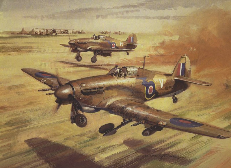 Due aerei da caccia britannici risalenti alla Seconda Guerra Mondiale volano a bassa quota sopra un campo d’aviazione erboso, con tende e altri aerei visibili sullo sfondo.